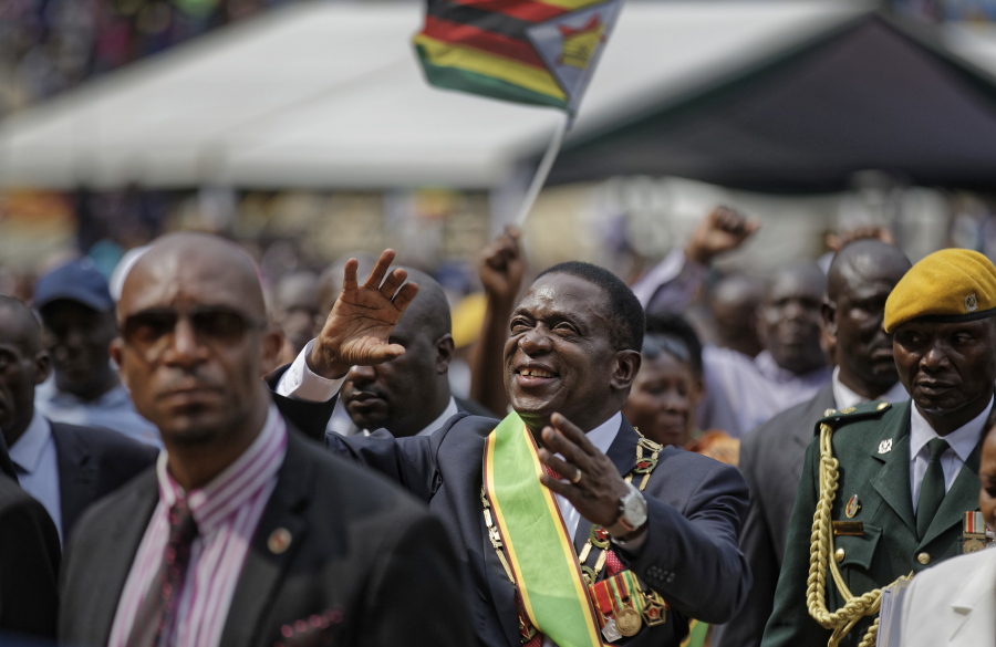Zimbabwe’s new president, Emmerson Mnangagwa, center, acknowledges the cheering crowd as he leaves his inauguration ceremony Friday in Harare, Zimbabwe.