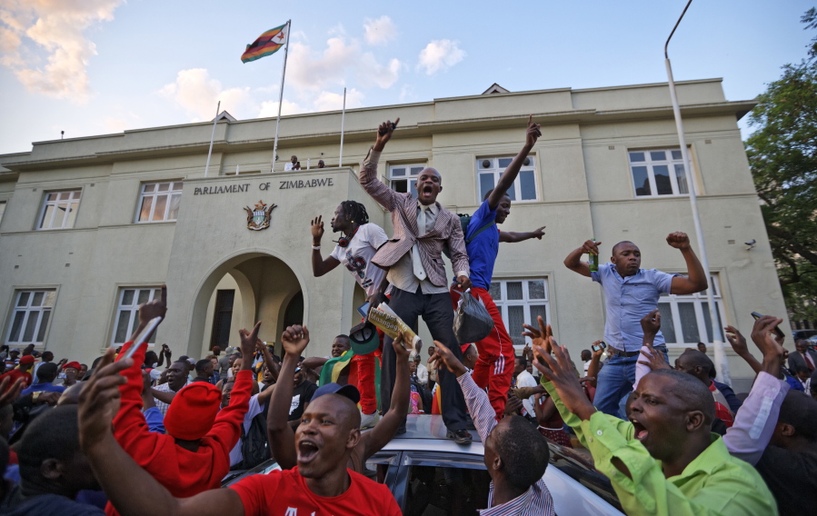 Zimbabweans celebrate outside the parliament building immediately after hearing the news that President Robert Mugabe had resigned, in downtown Harare, Zimbabwe, on Tuesday. Mugabe resigned as president with immediate effect Tuesday after 37 years in power, shortly after parliament began impeachment proceedings against him.