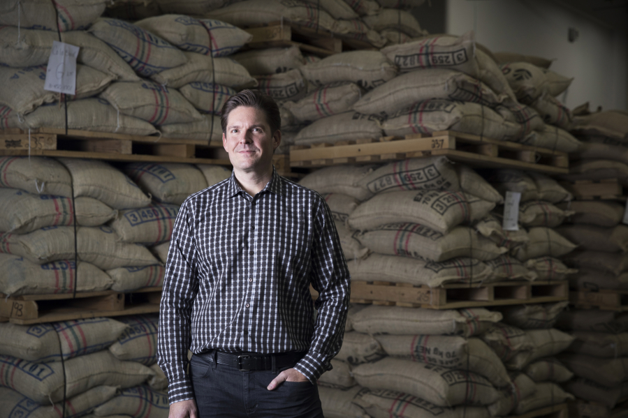 New Caribou president John Butcher with bags of coffee from around the world last month at Caribou headquarters.