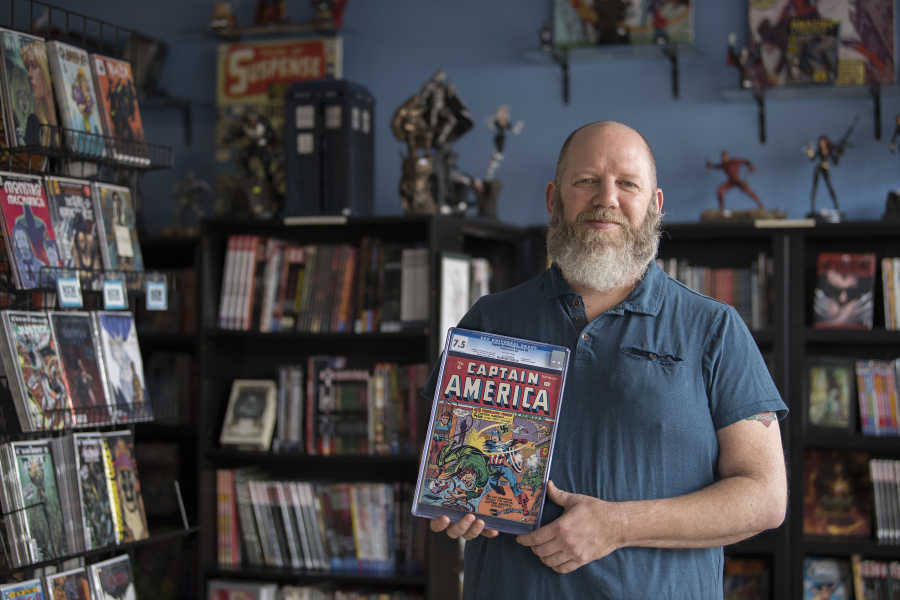 Chris Simons, owner of I Like Comics, pauses for a photo with a copy of “Captain America No. 6” from September 1941. The rare comic is one of perhaps 100 in existence.