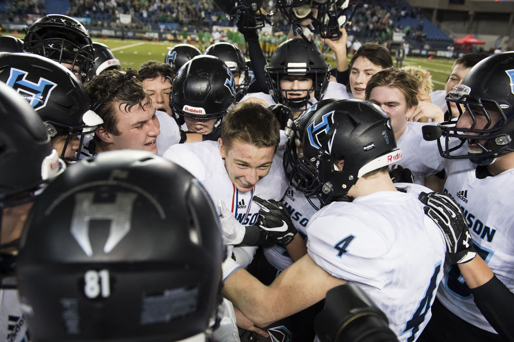 Hockinson surrounds quarterback Canon Racanelli as they celebrate their win against Tumwater after the 2A state football championship game Saturday, Dec. 2, 2017, in Tacoma, Wash.