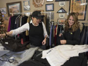 Navy veteran Jana Glover, left, of Vancouver picks out clothes Friday morning during the Suits for Soldiers event at Veterans of Foreign Wars Post 7824. She is assisted by Paula Dieringer with ServiceMaster of Portland.