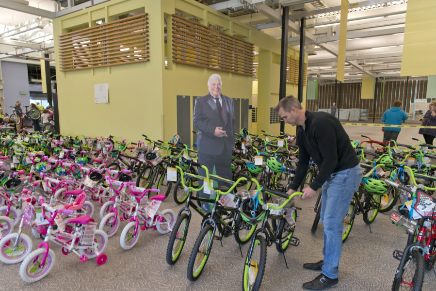 Jason Hudson, this year’s program director, parks a finished bicycle in front of a cutout of Scott Campbell, a Vancouver civic leader who was running for a city council seat when he died in September.
