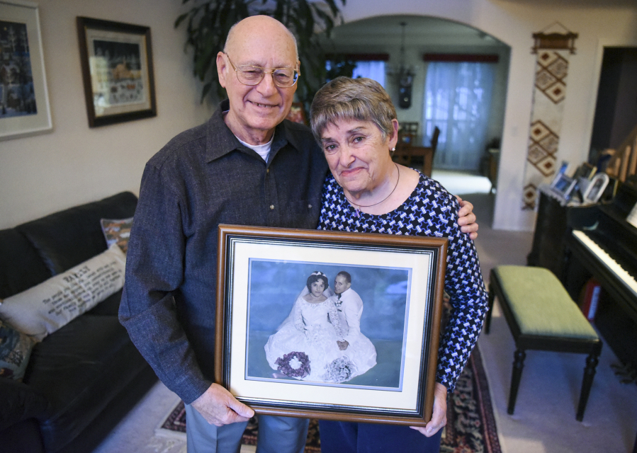 Les Burger, 77, and his wife, Julie Burger, 78, hold a portrait from their wedding in 1960 in their Vancouver home on Dec. 12. Julie, who was diagnosed with Alzheimer’s disease last year, can’t remember her wedding day.