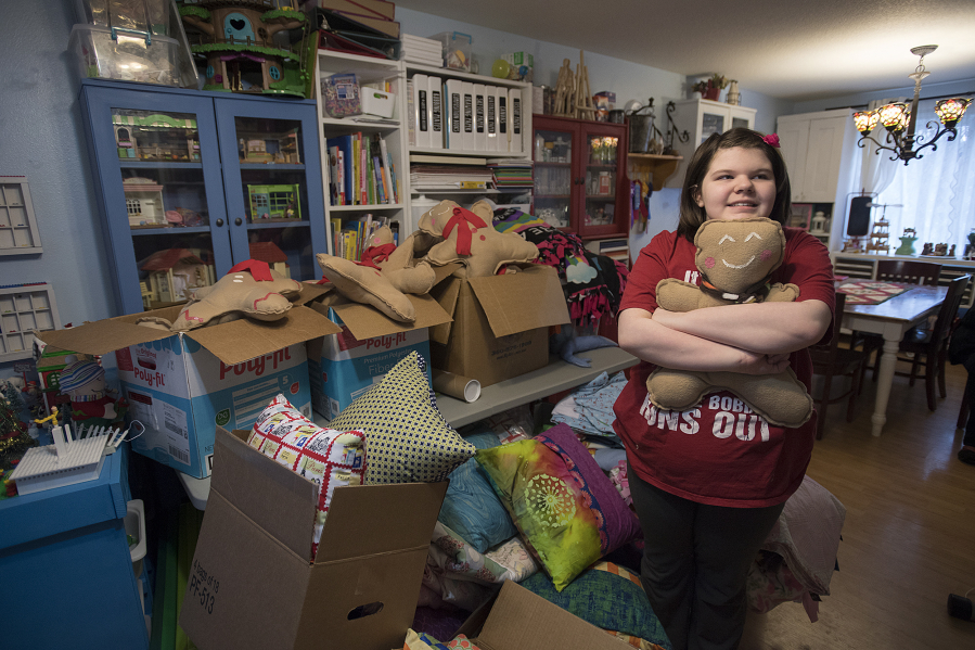 Vancouver resident Lucy Crouse, 10, is surrounded by some of the quilts and stuffed toys she made for Second Step Housing. Lucy, who has autism, has sewn 105 quilts and dozens of other gifts this year to donate to the Vancouver nonprofit.