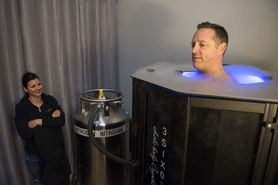 Liza Anzellotti monitors the cryotherapy sauna as her husband, Dave Anzellotti, demonstrates how it is used Tuesday at 3SIX0 Fitness in Vancouver. Whole-body cryotherapy is said to reduce inflammation and chronic pain, and accelerate athletic recovery.