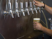 Tap room manager Berto Montes pours a draught beer at Ghost Runners Brewery in Vancouver in June.