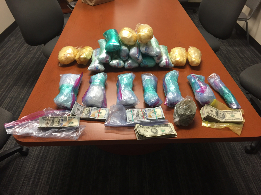 Law enforcement officers arrested one man and recovered 22 pounds of methamphetamine and $15,000 in cash, shown here, during a search of a home near PeaceHealth Southwest Medical Center Wednesday. The search was part of an ongoing drug trafficking investigation.