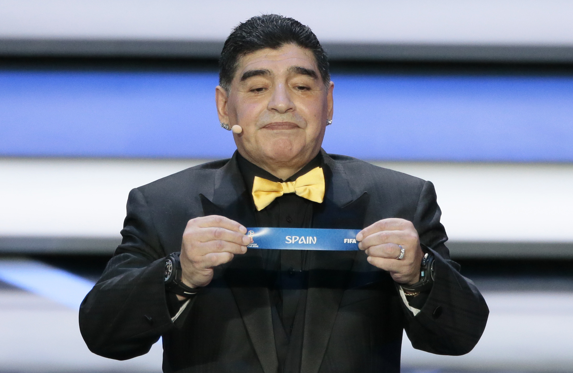 Argentine soccer legend Diego Maradona holds up the team name of Spain at the 2018 soccer World Cup draw in the Kremlin in Moscow, Friday, Dec. 1, 2017.