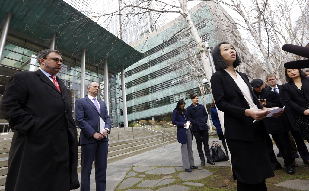 Mariko Hirose, right, a litigation director at the Urban Justice Center, addresses reporters as Mark Hetfield, president an CEO the Hebrew Immigrant Aid Society, left, and Rabbi Will Berkowitz, Jewish Family Service of Seattle CEO, look on in front of a federal courthouse after speaking with media members there Dec. 21 in Seattle. Lawyers representing refugees who have legally settled in the U.S. are asking a federal judge to stop the Trump administration from keeping refugee families from entering the country. The ACLU, representing a Somali man living in Washington state, argued in federal court Thursday that Trump's indefinite ban on letting those families into the U.S. violates immigration law and the constitutional rights of the legal permanent residents.
