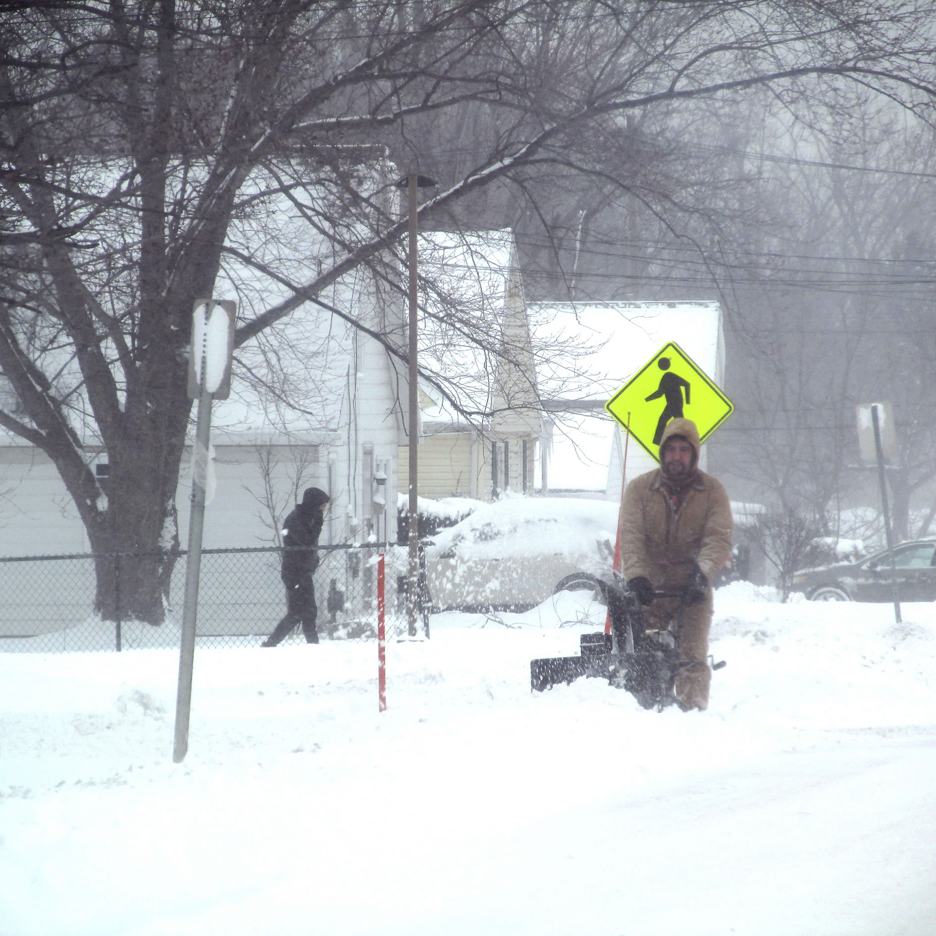 In this Tuesday, Dec. 26, 2017 photo, a man uses a snow blower to dig out after heavy snow fell in Dunkirk, N.Y. The National Weather Service said that strong westerly winds over Lake Erie picked up moisture, developed into snow and converged with opposing winds, dumping snow in a band along the shore from Ohio to New York.