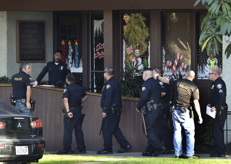 Police officers gather in front of law offices where a deadly shooting took place Friday in Long Beach, Calif.