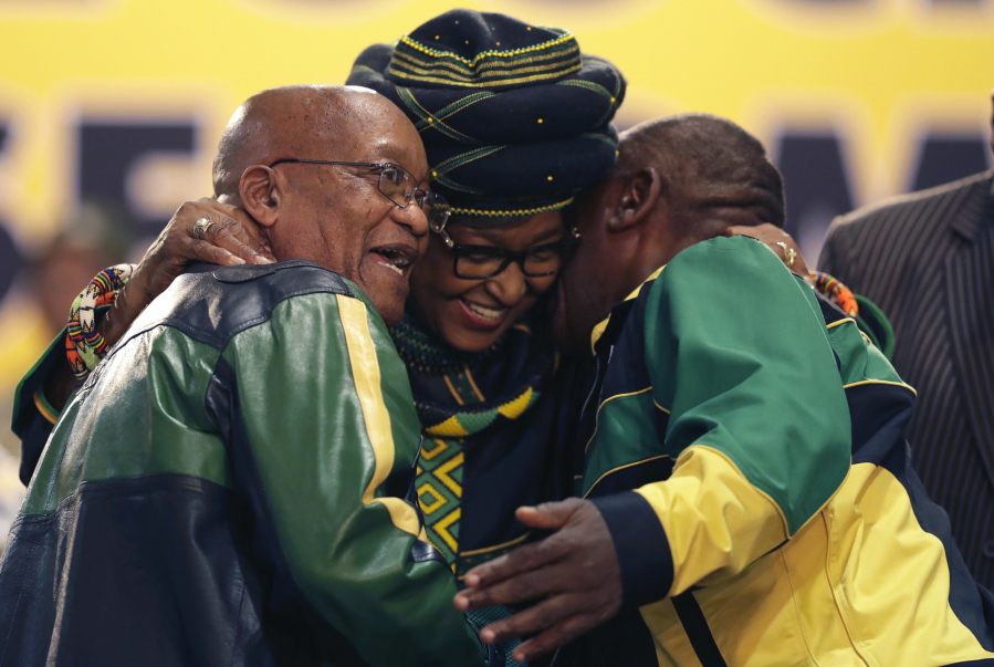 Winnie Madikizela-Mandela, centre, hugs front runner and Deputy President, Cyril Ramaphosa, right, and President Jacob Zuma, left, at the start of the ruling African National Congress (ANC) elective conference in Johannesburg, Saturday, Dec. 16 2017. The fight to replace South Africa’s scandal-prone President Jacob Zuma began Saturday as thousands of delegates of the ruling African National Congress gathered to elect a new leader, with Zuma acknowledging “failures” that have threatened the party’s future.
