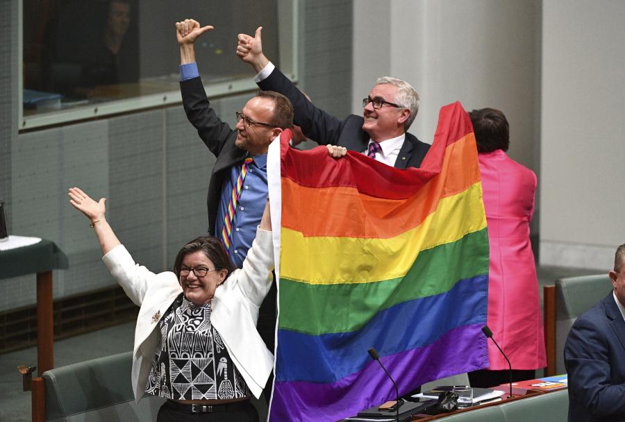 Members of Parliament, from left, Cathy McGowan, Adam Brandt and Andrew Wilkie celebrate the passing of the Marriage Amendment Bill in the House of Representatives at Parliament House in Canberra on Thursday.