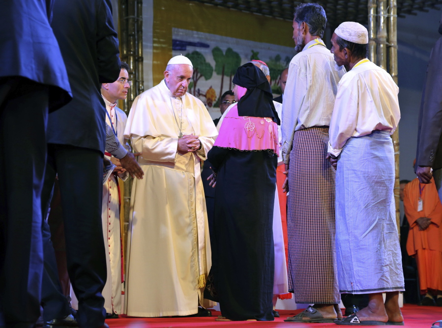 Pope Francis interacts with a Rohingya Muslim refugee at an interfaith peace meeting in Dhaka, Bangladesh, on Friday. Pope Francis ordained 16 priests during a Mass in Bangladesh on Friday, the start of a busy day that will bring him face-to-face with Rohingya Muslim refugees from Myanmar at an interreligious prayer for peace.