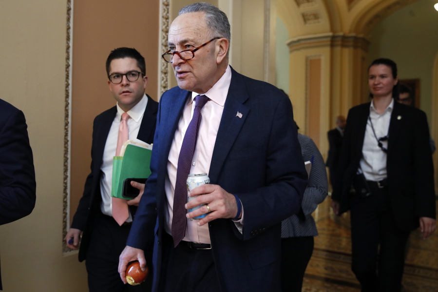 Senate Minority Leader Sen. Chuck Schumer of N.Y., center, walks through the Capitol, on Friday on Capitol Hill in Washington. Republican leaders believe they have the votes to approve a GOP overhaul of the tax code.