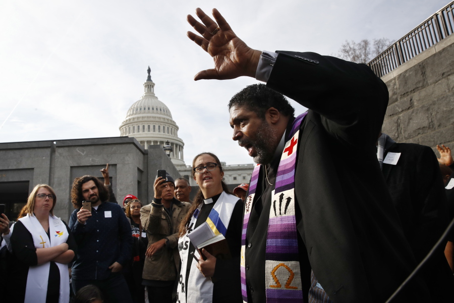 The Rev. William Barber II, with the “Poor People’s Campaign,” speaks to the group after they prayed inside of the Capitol Rotunda in protest of the GOP tax overhaul Monday on Capitol Hill in Washington.