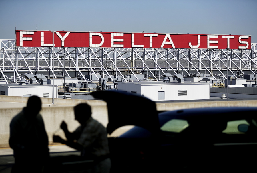 A Delta Air Lines sign overlooks the unloading area at Hartsfield-Jackson Atlanta International Airport, in Atlanta. On Thursday Delta announced it will order 100 Airbus A321neo jets with a sticker price of $12.7 billion and take an option to buy another 100 jets, a deal that Chicago-based Boeing had hoped to land.