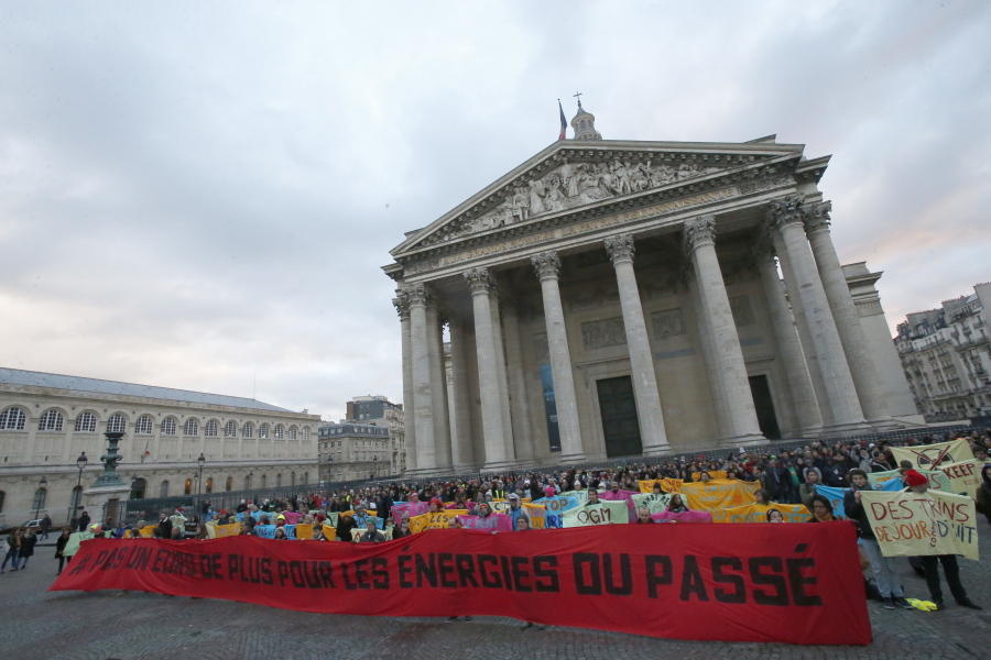 Environmental activists display a banner as they protest in support of the Paris climate accord, at Pantheon monument in Paris, France, on Tuesday. Banner reads: “Not one more euro for the energies of the past”. More than 50 world leaders are gathering in Paris for a summit that President Emmanuel Macron hopes gives new momentum to the fight against global warming despite U.S. President Donald Trump’s rejection of the Paris climate accord.