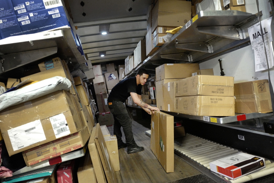 A UPS employee loads packages onto a truck at a company facility in New York. With Christmas on a Monday, most retailers have one less day to get packages delivered on time.