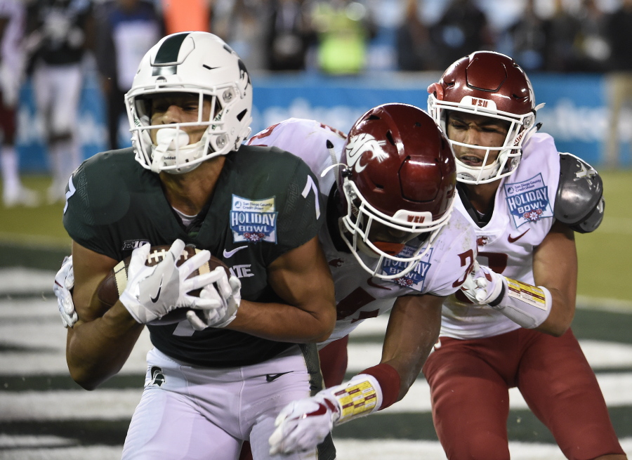Michigan State wide receiver Cody White (7) makes a touchdown catch in front of Washington State safety Jalen Thompson (34) and cornerback Darrien Molton, rear, during the first half of the Holiday Bowl NCAA college football game Thursday, Dec. 28, 2017, in San Diego.
