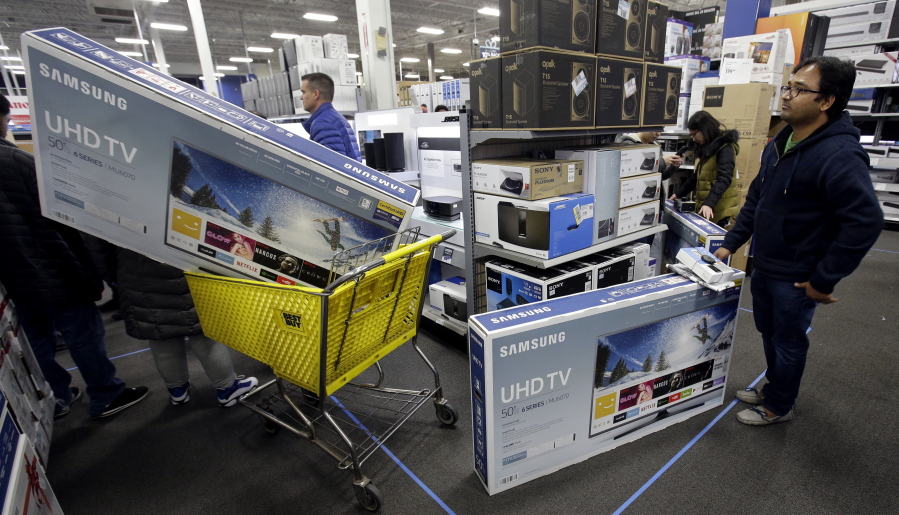 People wait to pay for televisions as they shop a sale at a Best Buy store on Thanksgiving Day in Overland Park, Kan.