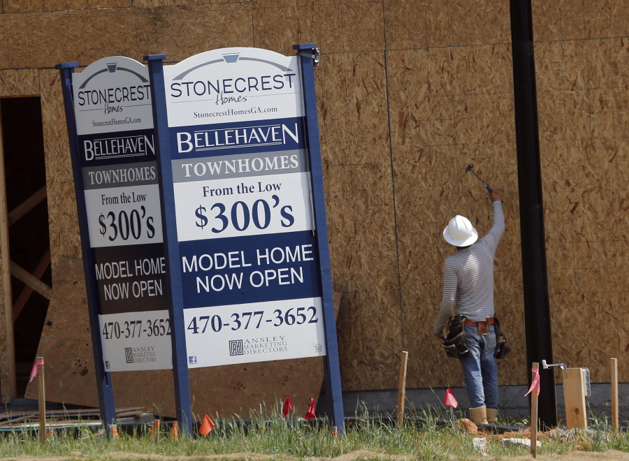 A construction worker continues work on new town homes under construction in Woodstock, Ga.