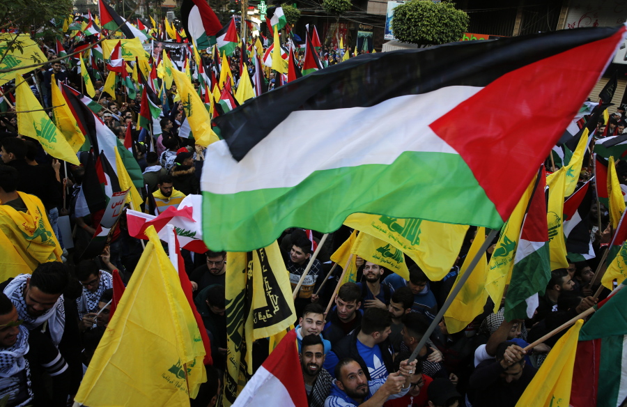 Protesters wave Palestinian, Lebanese and Hezbollah flags during a march in a street Monday in response to a call by Hezbollah leader Sheikh Hassan Nasrallah to protest U.S. President Donald Trump’s decision to recognize Jerusalem as the capital of Israel, in a southern suburb of Beirut, Lebanon.