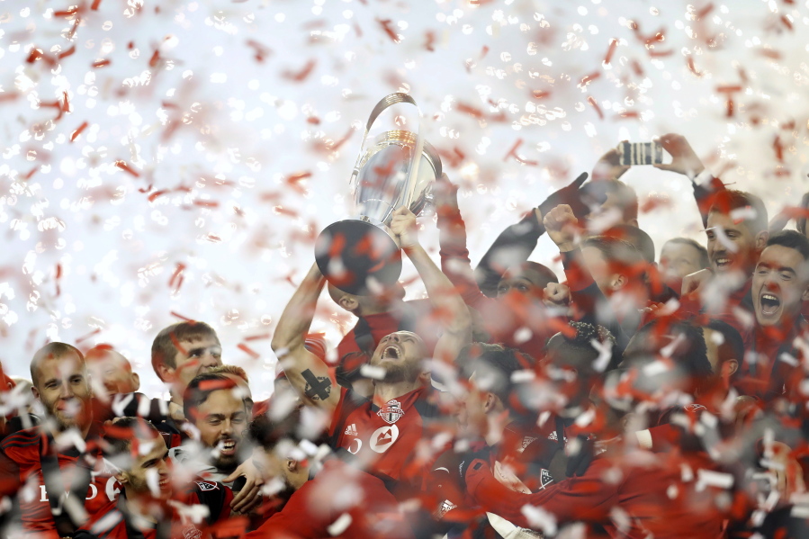 Toronto FC captain Michael Bradley hoists the trophy as the team celebrates its win over the Seattle Sounders in the MLS Cup final in Toronto, Saturday, Dec. 9, 2017.