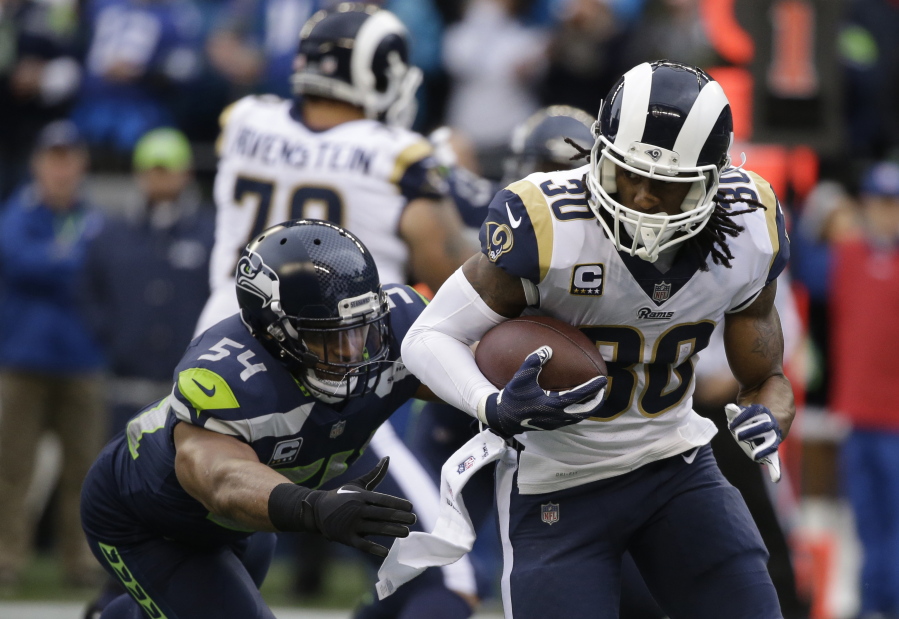 Los Angeles Rams running back Todd Gurley carries the ball as he gets ahead of Seattle Seahawks middle linebacker Bobby Wagner, left, Sunday in Seattle. Gurley had three touchdowns in the first half, while Wagner struggled with a hamstring injury that nearly prevented him from playing.
