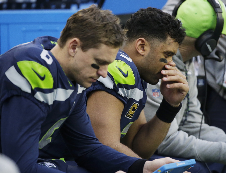Seattle Seahawks quarterback Russell Wilson, right, and backup quarterback Austin Davis, left, sit on the bench during the second half Sunday’s 42-7 loss to the Los Angeles Rams. The Seahawks have dominated the NFC West and never missed the playoffs since drafting Wilson in 2012. Now Seattle will need two straight wins and likely help from others to reach the postseason.