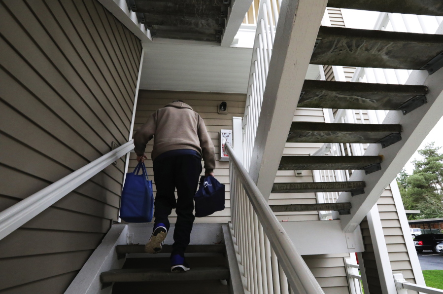 John Sparr, a volunteer with the Senior Activity Center in Renton, Wash., carries two bags of frozen meals to a Renton apartment complex for a needy recipient on Nov. 29, 2017. With baby boomers retiring, King County’s senior population is expected to double from 2008 to 2025. Boomers haven’t exactly planned ahead. Only 55 percent have saved any money for retirement, according to the Insured Retirement Institute, a nonprofit composed of 150,000 finance professionals.