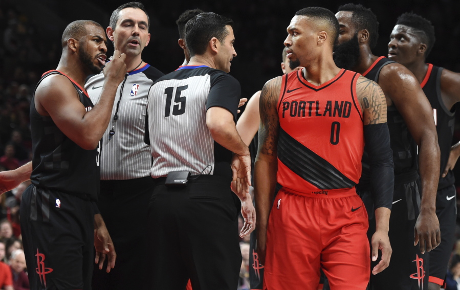 Houston Rockets guard Chris Paul, left, exchanges words with Portland Trail Blazers guard Damian Lillard after being called for a foul when he knocked Lillard down during the first half of an NBA basketball game in Portland, Ore., Saturday, Dec. 9, 2017.
