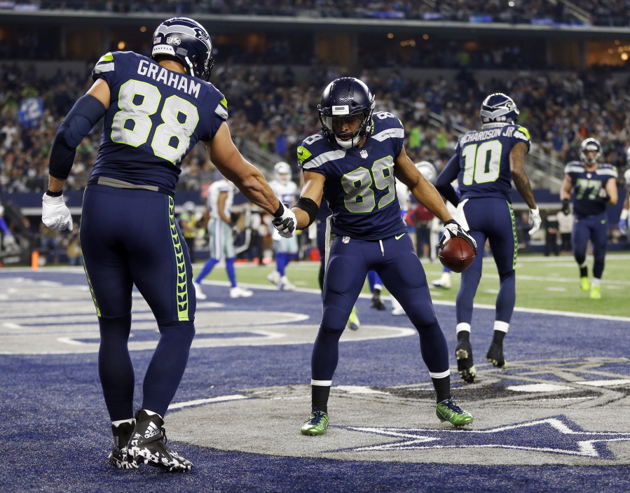 Seattle Seahawks’ Jimmy Graham (88) congratulates Doug Baldwin (89) on his touchdown catch in the second half of an NFL football game against the Dallas Cowboys on Sunday, Dec. 24, 2017, in Arlington, Texas.