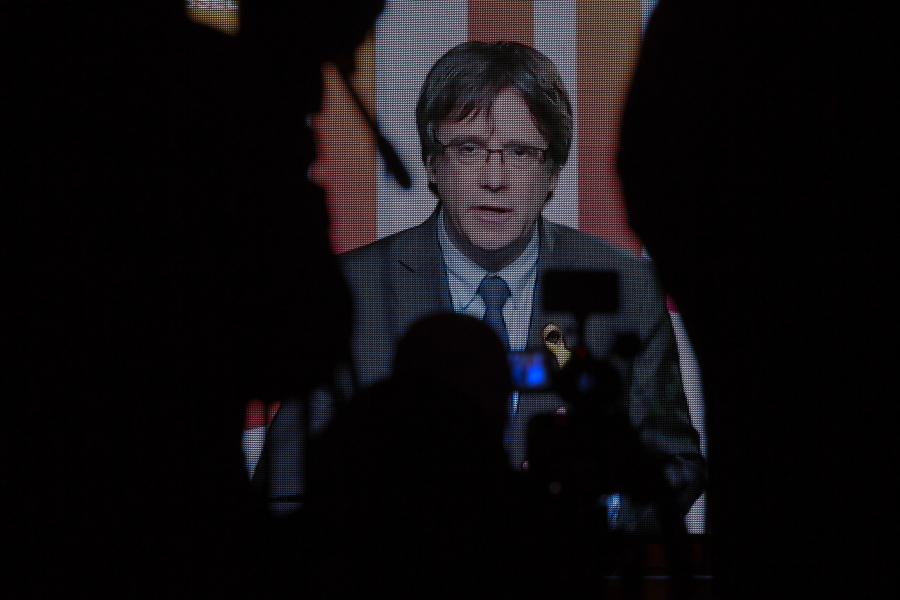 Ousted Catalan president Carles Puigdemont appears via video link from Brussels, on a screen during the electoral campaign for the Catalan regional election in Barcelona, Spain, Tuesday, Dec. 19, 2017. Political parties for and against Catalonia’s independence from Spain were making a final effort to convince voters as campaigning for a regional election ends Tuesday.