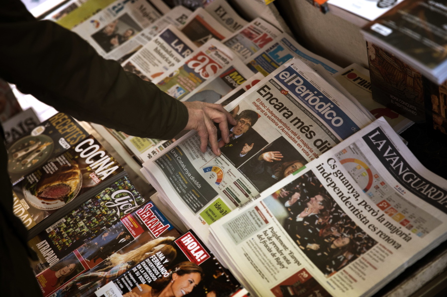 A man buys a newspaper featuring the results at the Catalan regional election, at a news stand in Barcelona, Spain, on Friday, Dec. 22, 2017. Elections in Catalonia have failed to clarify the restive region’s immediate future, exposing a deep and broad split between those for and against independence from Spain.