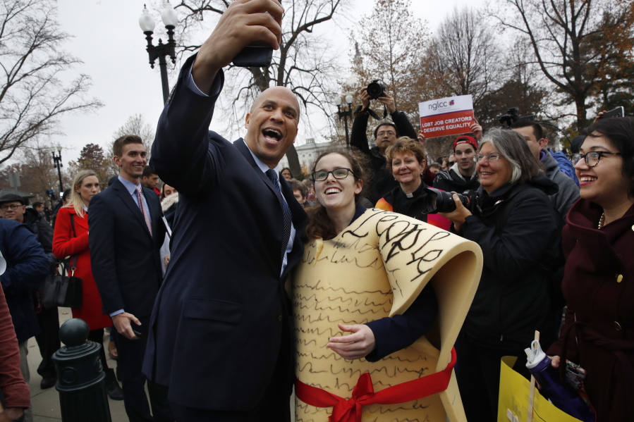 Sen. Cory Booker, D-N.J., left, takes a selfie with Caitlin Rooney, who is with the Center for American Progress and dressed as the Constitution, during a rally outside of the Supreme Court which is hearing the 'Masterpiece Cakeshop v. Colorado Civil Rights Commission' today, Tuesday, Dec. 5, 2017, in Washington.