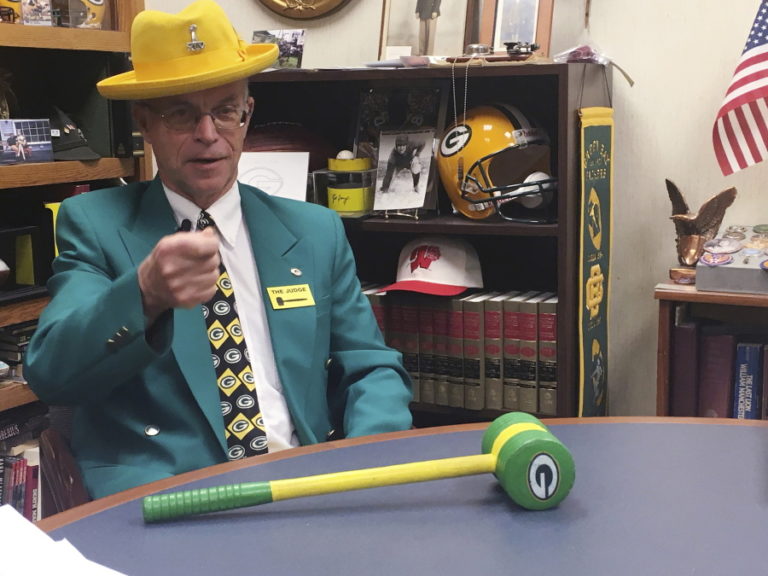 Outagamie County Circuit Court Judge John Des Jardins talks about his Green Bay Packers-themed gavel at his chambers in Appleton, Wis. Des Jardins attended the coldest NFL game on record between the Dallas Cowboys and Green Bay Packers 50 years ago at Lambeau Field, a game that became known as the “Ice Bowl.” (AP Photo/Genaro C.
