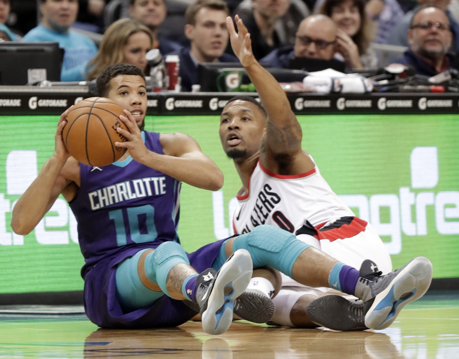 Charlotte Hornets' Michael Carter-Williams (10) looks to pass as Portland Trail Blazers' Damian Lillard (0) defends during the first half of an NBA basketball game in Charlotte, N.C., Saturday, Dec. 16, 2017.