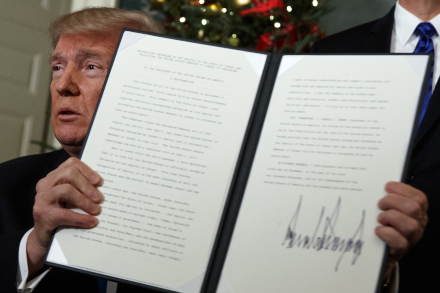 President Donald Trump holds up a proclamation to officially recognize Jerusalem as the capital of Israel, in the Diplomatic Reception Room of the White House, Wednesday, in Washington.