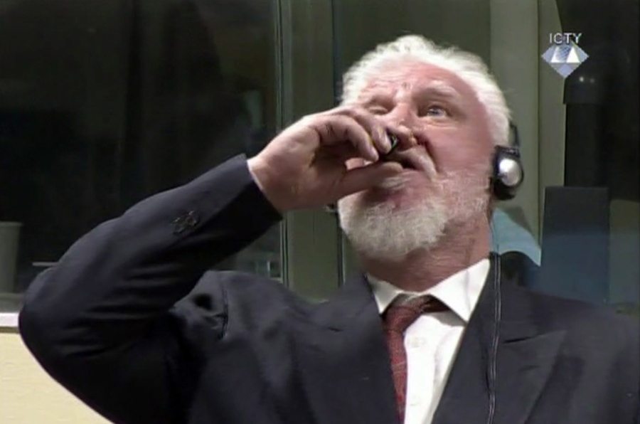 In this photo provided by the ICTY on Wednesday, Nov. 29, 2017, Slobodan Praljak brings a bottle to his lips, during a Yugoslav War Crimes Tribunal in The Hague, Netherlands. Praljak yelled, “I am not a war criminal!” and appeared to drink from a small bottle, seconds after judges reconfirmed his 20-year prison sentence for involvement in a campaign to drive Muslims out of a would-be Bosnian Croat ministate in Bosnia in the early 1990s.