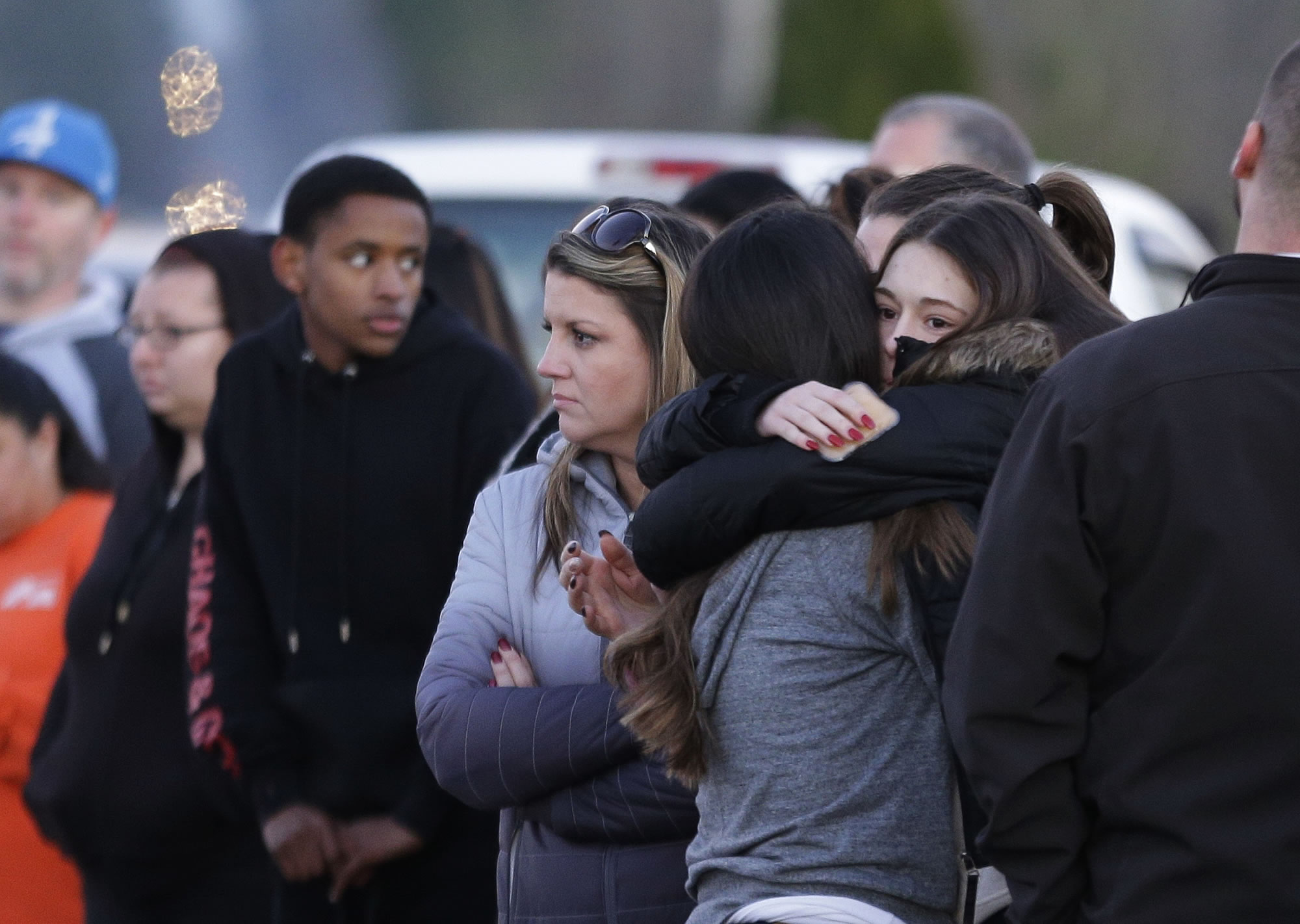 Two people hug as they wait to be reunited with students on lockdown near Graham-Kapowsin High School, Frontier Middle School, and Nelson Elementary School, Tuesday, Dec. 5, 2017, in Graham, Wash. Authorities said two students were shot near the high school Tuesday afternoon. (AP Photo/Ted S.