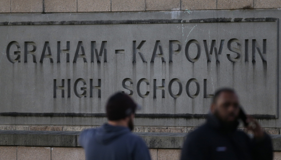People wait to be reunited with students on lockdown near a sign for Graham-Kapowsin High School, Tuesday, Dec. 5, 2017, in Graham, Wash. Authorities said two students were shot near the school Tuesday afternoon. (AP Photo/Ted S.