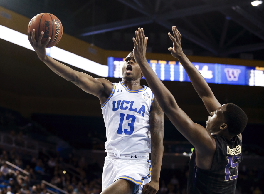 UCLA guard Kris Wilkes, left, goes to the basket while defended by Washington forward Noah Dickerson during the second half of an NCAA college basketball game in Los Angeles, Sunday, Dec. 31, 2017. UCLA won 74-53. (AP Photo/Ringo H.W.