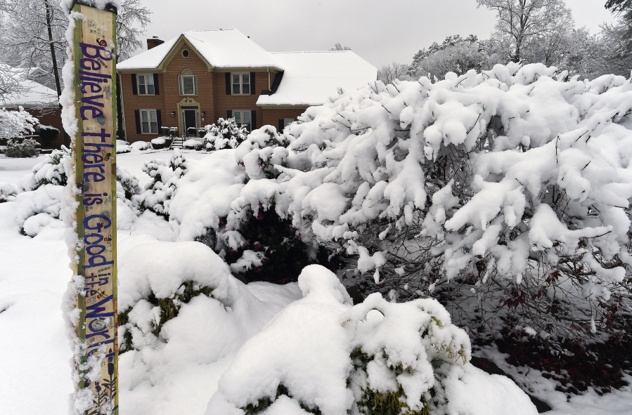 Heavy snow weighs down shrubs in front of a home, Saturday, Dec. 9, 2017, in Kennesaw, Ga. The frigid temperatures behind a cold front combined with moisture off the Gulf of Mexico to bring unusual wintry weather to parts of the South.