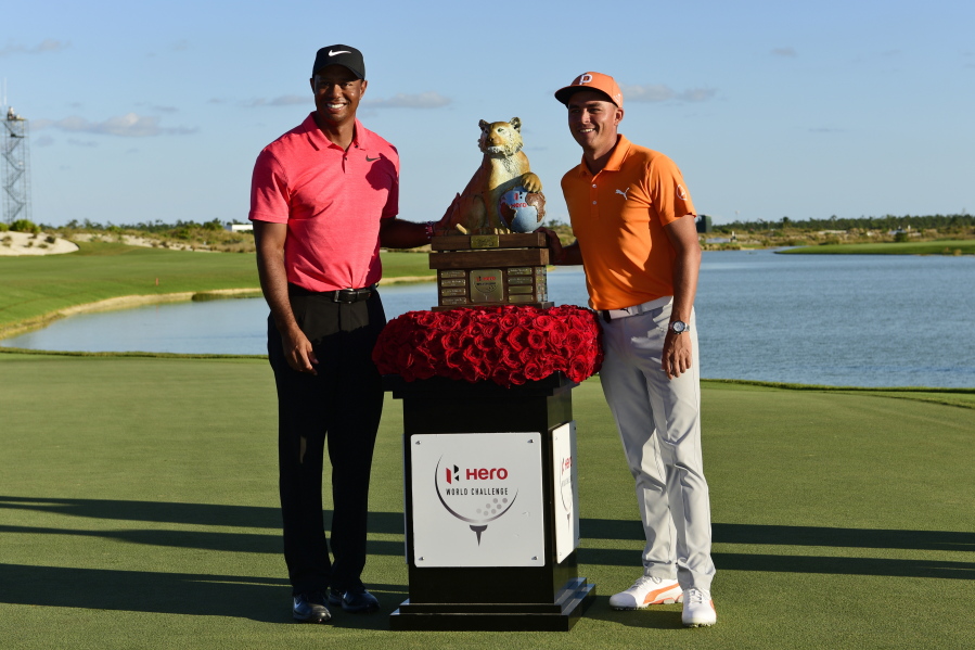 Rickie Fowler, right, poses with Tiger Woods and the trophy after Fowler won the Hero World Challenge golf tournament at Albany Golf Club in Nassau, Bahamas, Sunday, Dec. 3, 2017.