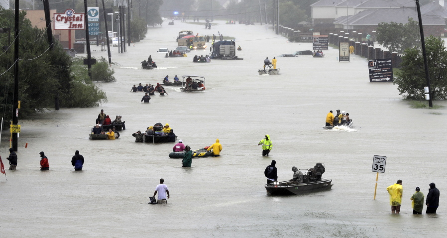 Rescue boats float on a flooded street as people are evacuated from rising floodwaters brought on by Tropical Storm Harvey on Aug. 28 in Houston.