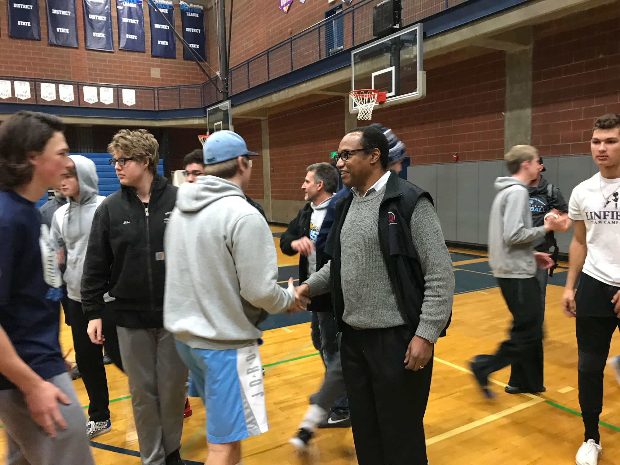 3-time NFL Pro Bowler and Ex-Seattle Seahawks running back Curt Warner (right) greets members of Hockinson's football players after addressing the team Friday before their send-off to Tacoma.