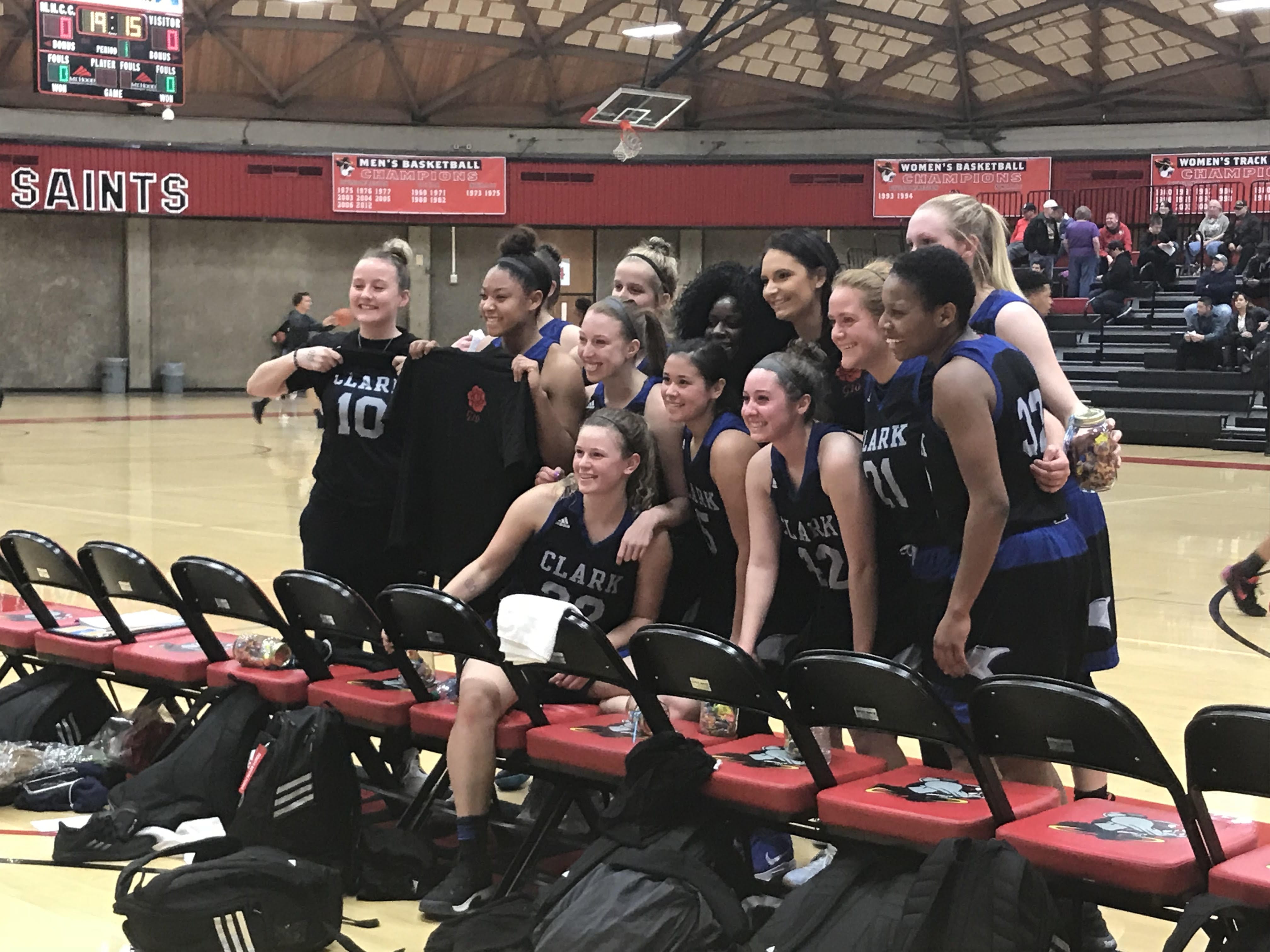 The Clark College women's basketball team pose a photo after getting its first win of the season just five days after the sudden passing of their teammate, freshman Gianna Loville.