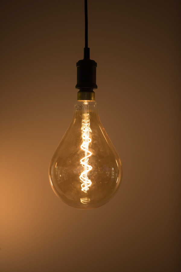 A filament glows inside a Philips Classic LED light bulb.